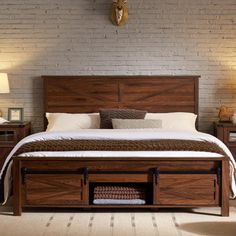 a bed with two drawers underneath it in a room that has brick walls and flooring