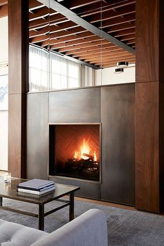 a living room filled with furniture and a fire place in the middle of a wall