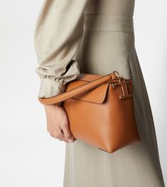 Bauletto in soft leather characterized by a front flap pocket, it is enhanced by the T-stitching detailing. Featuring a slightly padded handle strap and a removable shoulder strap, it comes with a zip closure and a back zipped pocket. The covered T Timeless accessory adorns the side of this soft and elegant line creation. Timeless Tan Shoulder Bag For Work, Tan Leather Shoulder Bag For Work, Tan Shoulder Bag For Work, Tan Calf Leather Shoulder Bag For Business, Cognac Calf Leather Shoulder Bag For Work, Tan Leather-lined Shoulder Bag For Work, Tan Leather Lined Shoulder Bag For Work, Tan Shoulder Bag With Leather Lining For Work, Timeless Tan Soft Leather Shoulder Bag