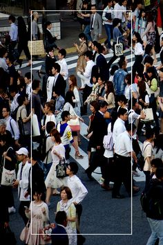 a crowd of people walking across a street