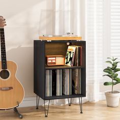 a small wooden shelf with some records and a guitar