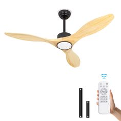 a person is holding a remote control in front of a ceiling fan with two blades