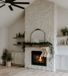 a living room with a fire place and christmas decorations on the fireplace mantels