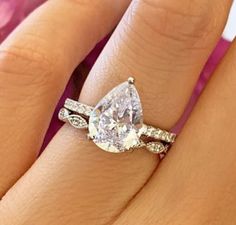 a woman's engagement ring with a pear shaped diamond