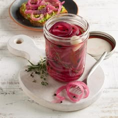 a jar filled with pickled onions sitting on top of a plate