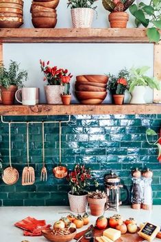 the kitchen counter is covered with pots and pans filled with vegetables, fruit, and bread