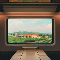 an empty table in front of a large window with a view of the countryside outside