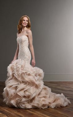 a woman in a wedding dress standing on a wooden floor