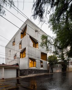 the building is made out of concrete and has multiple windows on each side, along with two balconies