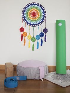 a colorful dream catcher hanging on the wall next to a yoga mat and other items