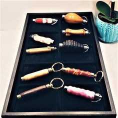 an assortment of different sized and shaped objects in a black tray next to a potted plant