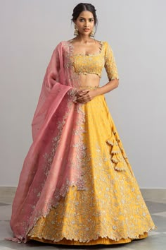 a woman in a yellow and pink lehenga