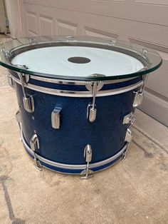 a blue drum sits on the floor in front of a garage door with a glass top