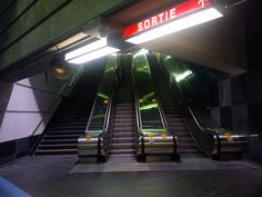 an escalator with two sets of stairs leading up to the second floor in a subway station