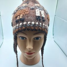 a mannequin head wearing a knitted hat with white and brown designs on it