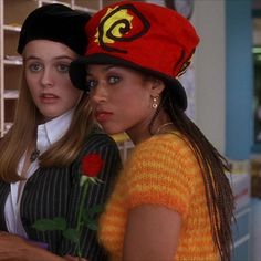 two young women wearing hats standing next to each other