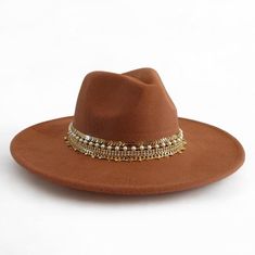 Dazzle in Nashville with this stunning vegan suede rancher hat, handcrafted with 5 rows of sparkling jewelry and trim. This statement hat is perfect for adding a touch of Western flair to any outfit, whether you're dressing up for a night out on the town or keeping it casual for a day of exploring. Made with high-quality vegan suede, this hat is both stylish and comfortable. The wide brim provides sun protection, while the adjustable sweatband ensures a perfect fit.       This hat is sure to turn heads and make you feel like a star. Order yours today!       Details:       + Color: Tan Brown    + Brim size: 3 inches    + Jewelry and trim: A mix of beads, chains, and trims    + Care: Spot clean    + One size fits most women 22-23 " or ( 56-57cm)    it has adjustable straps to to ensure a com Wide Brim Hat For Western-themed Fall Events, Brown Flat Crown Felt Hat For Spring, Brown Felt Hat With Flat Crown For Summer, Brown Flat Crown Felt Hat For Summer, Summer Brown Felt Hat With Flat Crown, Brown Summer Felt Hat With Flat Crown, Bohemian Style Fedora Sun Hat For Parties, Bohemian Fedora Sun Hat For Party, Bohemian Fedora With Short Brim For Party