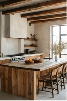 a kitchen with an island counter top and wooden chairs in front of the stovetop