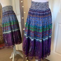 Patterned Cotton Midi Skirt Smocked Waistband Unlined Ruffle Tiered Design 100% Cotton Casual Purple Skirt With Elastic Waistband, Casual Purple Beach Skirt, Casual Purple Skirt For Beach, Bohemian Knee-length Skirt With Elastic Waistband, Purple Skirt With Elastic Waistband For Summer, Purple Long Skirt For Beach, Long Purple Beach Skirt, Casual Purple Skirted Bottoms, Casual Purple Lined Skirt Bottoms