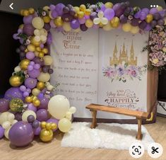 a table with balloons and a bench in front of an open book on the floor