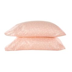 two pillows on top of each other with white polka dot print in pink and beige