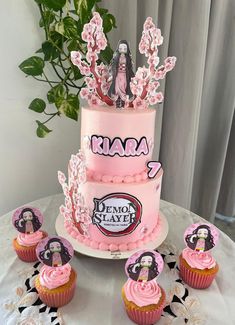 a pink cake and cupcakes on a table