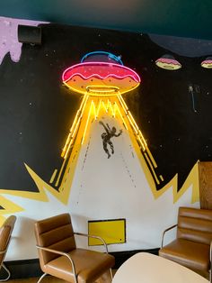 a room with chairs and a neon sign on the wall