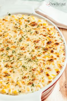 a casserole dish with cheese and herbs in it on a wooden table top