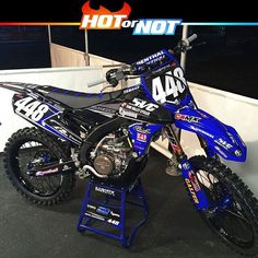 a blue dirt bike sitting on top of a stand