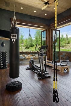 there is a gym with many exercise equipment in the room and one has a punching bag