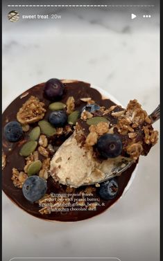 an image of a dessert on a plate with nuts and blueberries in the middle