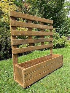 a wooden planter sitting on top of a lush green field