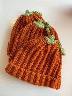 an orange knitted hat sitting on top of a white table