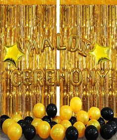 some black and gold balloons are in front of golden foil curtaines that say happy new year