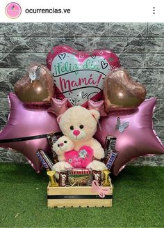 a teddy bear sitting on top of a wooden box filled with balloons and chocolates