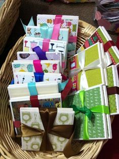 a basket filled with lots of different types of gift boxes next to a pile of cards