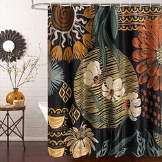 a shower curtain with an orange flower and leaves on it, next to a white brick wall