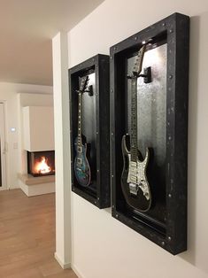 two guitars are hanging on the wall