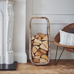 a wicker basket filled with firewood next to a fireplace