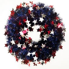 a wreath with red, white and blue tinsel stars on the front is shown