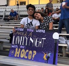 two people sitting on bleachers holding a sign that says, would you want a lovely night with me hoco?