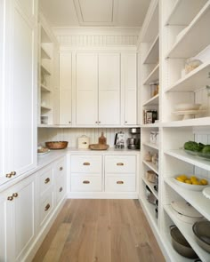 a kitchen with white cabinets and wooden floors