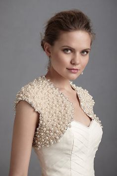 a woman in a white dress with pearls on it