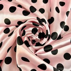 a pink and black polka dot print fabric with large black dots on the top of it