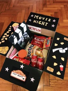 an open box filled with movies and snacks on top of a hard wood floor next to a wooden floor