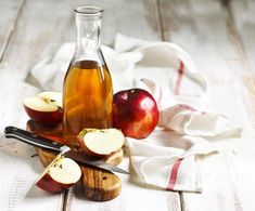 an apple cider and some sliced apples on a table