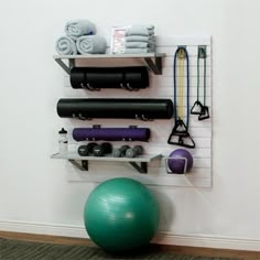 there is a gym ball, exercise equipment and other items on the wall in this room