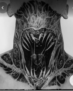 the back of a man's neck is covered in intricate designs and features tattoos