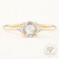 an oval cut diamond ring with three diamonds on the band and side stones in yellow gold