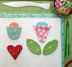 a piece of fabric with flowers and hearts on it, next to a pair of scissors